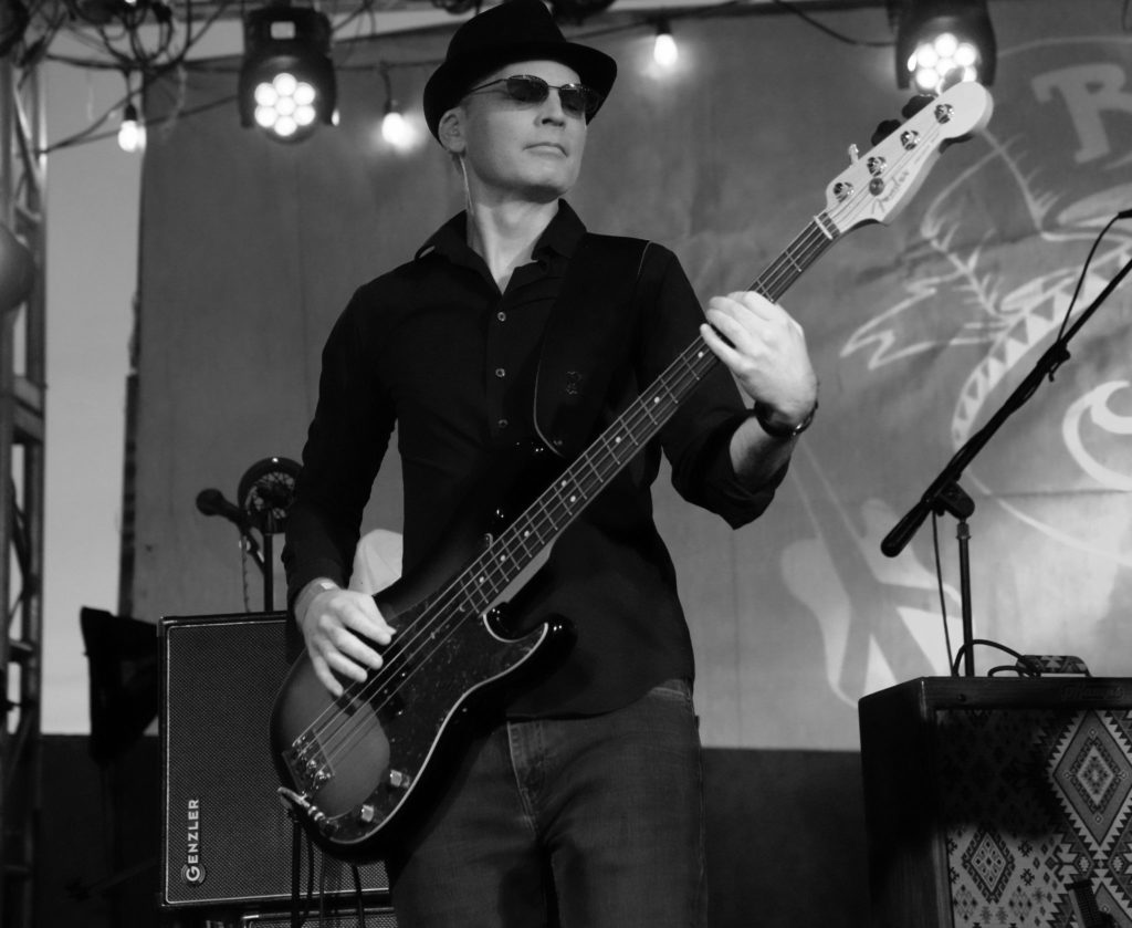 Black and white photo of bassist on outdoor stage