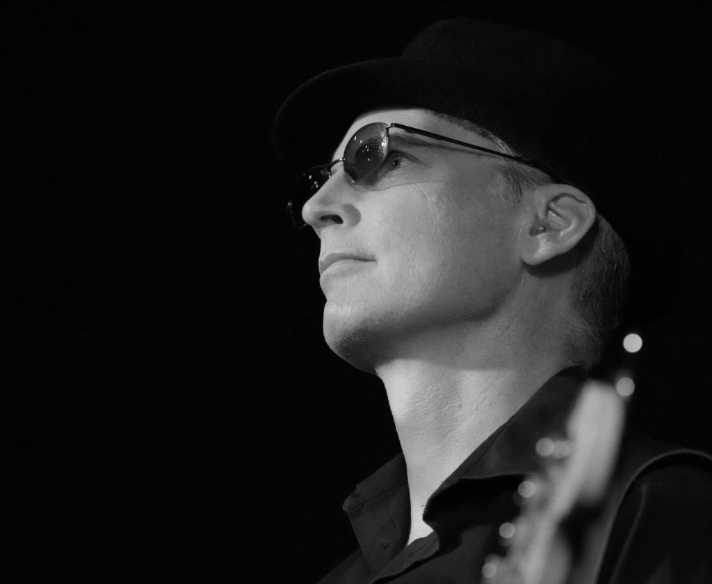 Black and white closeup photo of a bassist