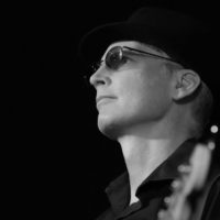 Black and white closeup photo of a bassist