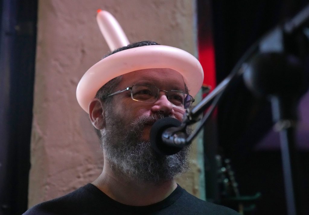 Closeup of singer on stage with a balloon tied around his head