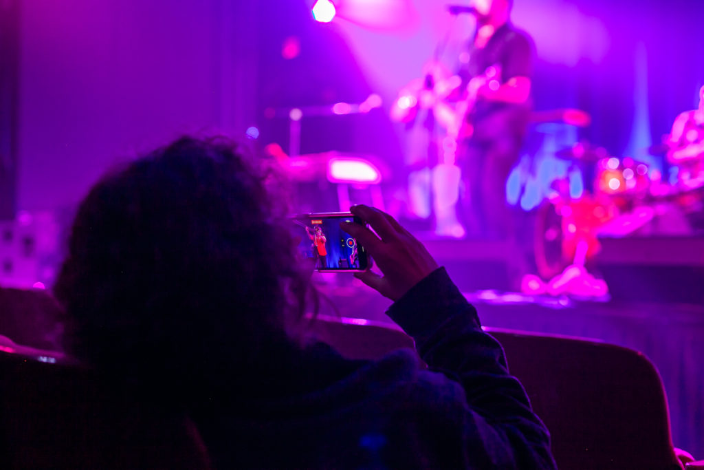 audience member recording the band on stage
