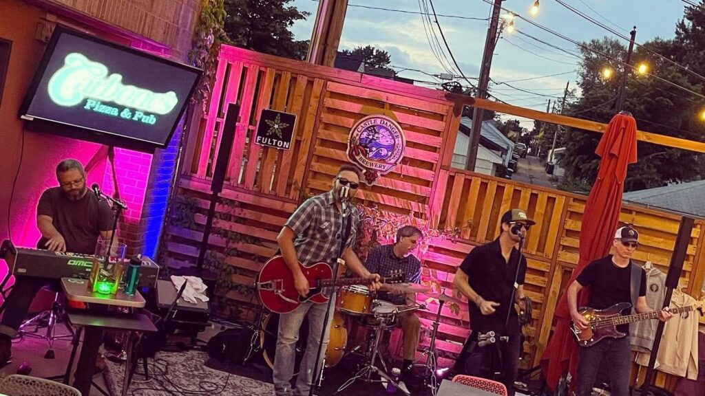 Five piece rock and roll band plays on the Carbone's patio in the Nokomis Neighborhood of Minneapolis.